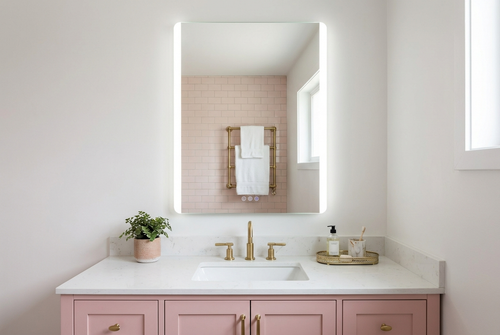 Bathroom with pink vanity, white countertop, and illuminated mirror.