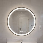 Round illuminated bathroom mirror on a tiled wall