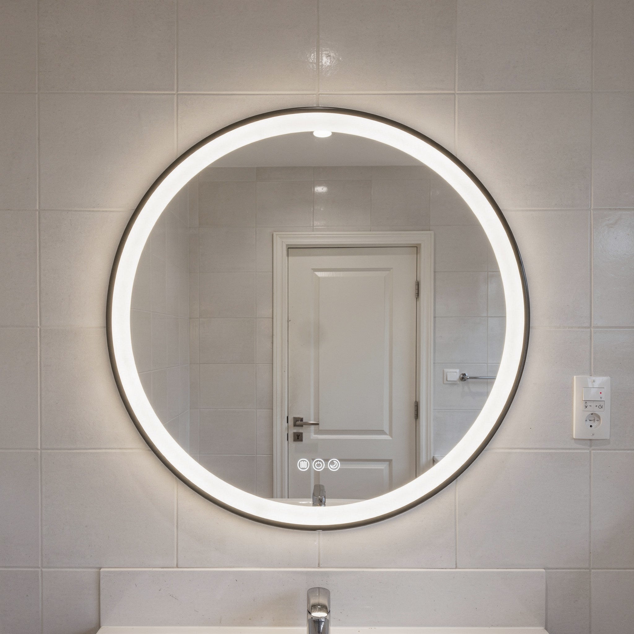 Round illuminated bathroom mirror on a tiled wall