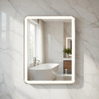 Bathroom with a illuminated LED mirror reflecting a bathtub and window.