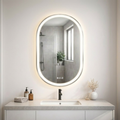 Bathroom vanity with a round illuminated mirror, sink, and toiletries.